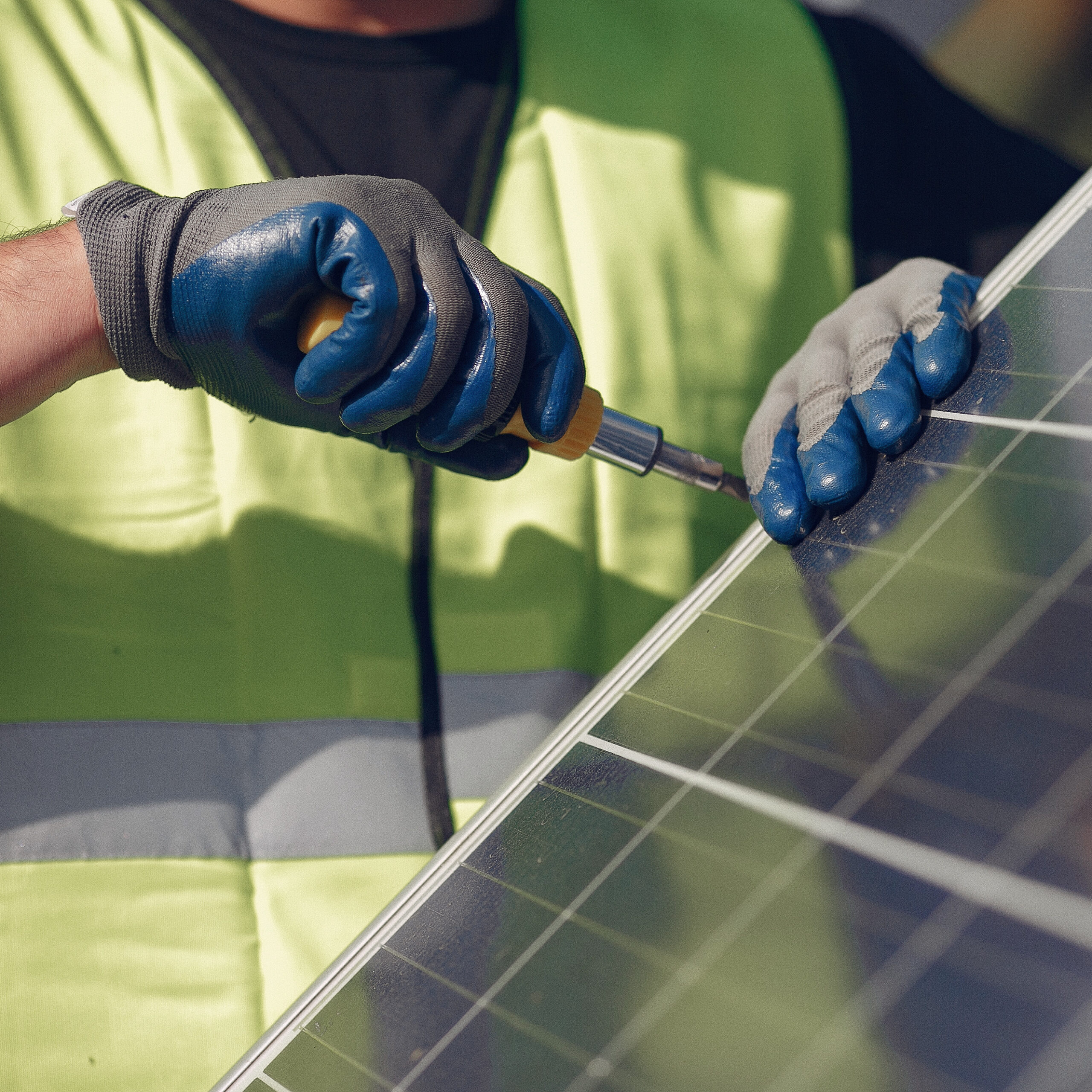 Man in a white helmet near a solar panel